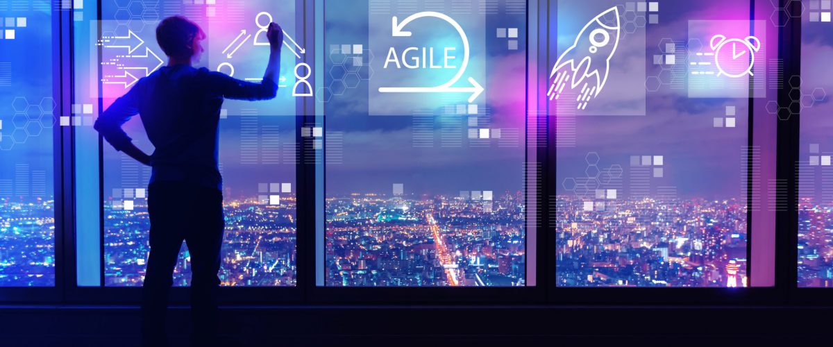 Agile concept with man writing on large windows high above a sprawling city at night